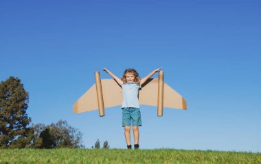 Gökyüzünde kanatları olan çocuk bir pilot hayal ediyor ve uçmayı hayal ediyor. Çocuklar macera, çocuklar özgürlük ve hayal gücü kavramı.