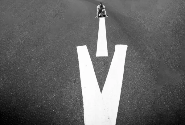 Runner on the start. Athlete man in running start pose on the city street. — стоковое фото