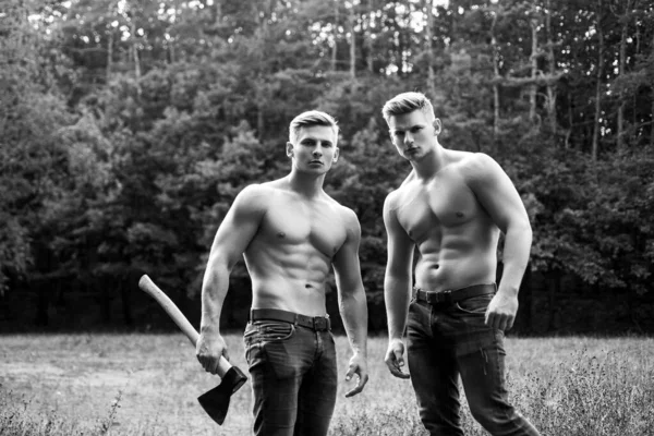 Männerpower. Zwei muskulöse, sexy junge Männer mit nacktem Oberkörper. Holzfäller brutal muskulös Jungs. — Stockfoto