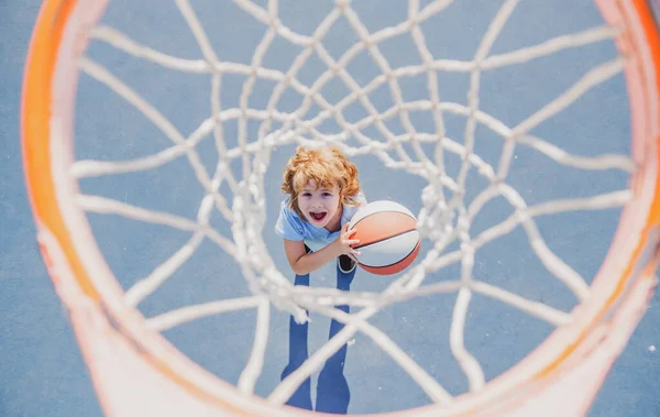 Csodálkozó gyerek kosarazik kezében labda boldog arccal. — Stock Fotó