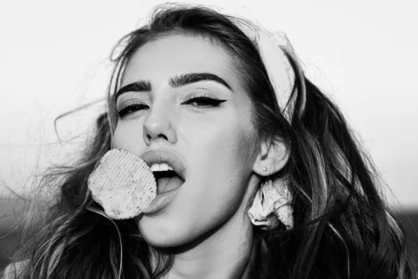 セクシーな女の子、口の中で保持チップを食べる。空腹の女性の顔を閉じて. — ストック写真