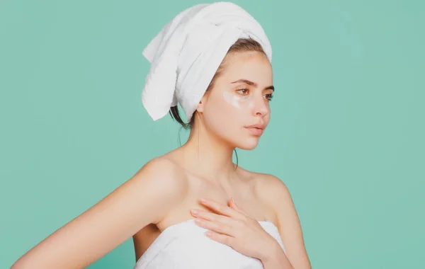 Young woman with calm face, enjoys bath procedures, wrapped towel on head, isolated on studio background. — Foto de Stock