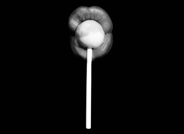 吹工作的概念。女人的嘴唇吸棒棒糖。一个女人把棒棒糖塞到嘴里，被黑色隔离。红唇、性感性感的概念. — 图库照片