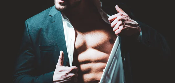 Sexy mannelijk lichaam in pak. Zakenman uitkleden pak op zwarte achtergrond. — Stockfoto