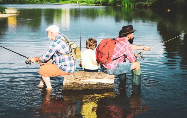 Old and young. Young - adult concept. Fly fishing for trout. Little boy on a lake with his father and grandfather. Father teaching son how to fly-fish in river. — Stock Photo, Image