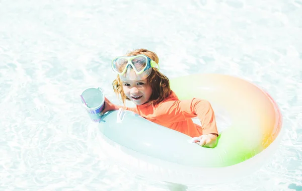 Šťastné dítě hraje s barevným plaveckým prstenem v bazénu v letní den. Dětské vodní hračky. Děti si hrají v tropickém letovisku. Rodinná dovolená na pláži. — Stock fotografie