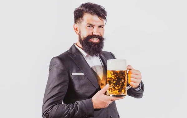 Schöner Mann im schwarzen Anzug trinkt Bier vor weißem Hintergrund. — Stockfoto