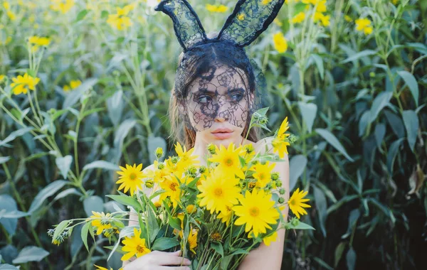 Vrolijk Pasen. Voorjaars konijntje met bloemen. Konijnenmeisje buiten. Boeket bloemen. — Stockfoto
