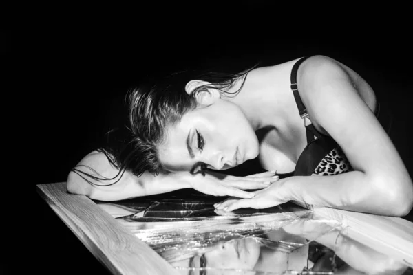 Meisje met gebroken spiegel. Elegante jonge vrouw poserend over een zwarte achtergrond. Licht en schaduw. Portret van een schoonheid vrouw gezicht. — Stockfoto