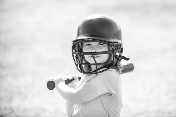 Portrait of kid in baseball helmet and baseball bat ready to bat.