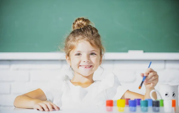 Schoolmeisje leerling tekent een tekening. Schattig klein kleuter kind tekening op school. — Stockfoto