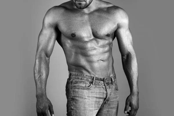 Άντρας με σέξι σώμα. Μυϊκός κορμός σέξι νεαρός άνδρας bodybuilder δύναμη αθλητικός άνθρωπος με τέλειους μυς κοιλιακούς και γυμνό στήθος σε γκρι φόντο. — Φωτογραφία Αρχείου