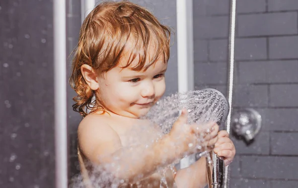 Was zuigelingenhygiëne en gezondheidszorg. Schattige baby wassen in de badkamer. Een jongen met zeepcapsules op zijn haar die een bad neemt. Grappige kinderen gezicht close-up. — Stockfoto