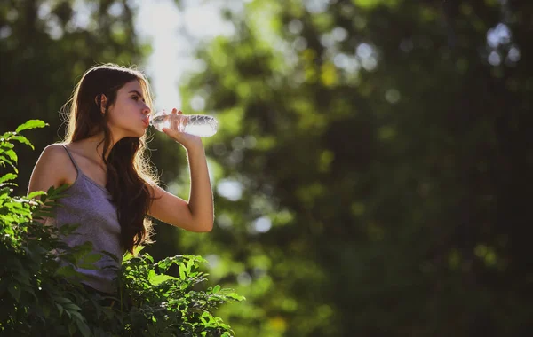 Healthy woman drinking water from bottle outdoor. Stay hydration concept. Unhidrated. Unity with nature, — Stock Photo, Image