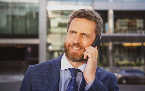 Unternehmerporträt. Der Mann auf dem Smartphone. Lässiger urbaner Geschäftsmann mit Smartphone, der glücklich lächelt. Schöner Mann im Anzug im Freien. — Stockfoto
