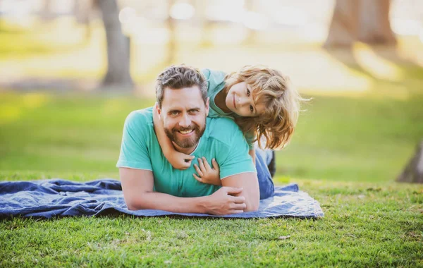 Счастливые отец и сын наслаждаются летним отдыхом в солнечном парке. — стоковое фото