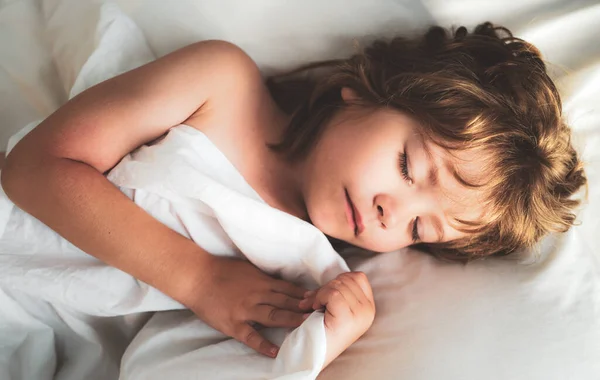 Crianças adormecidas jaz na cama com os olhos fechados. — Fotografia de Stock