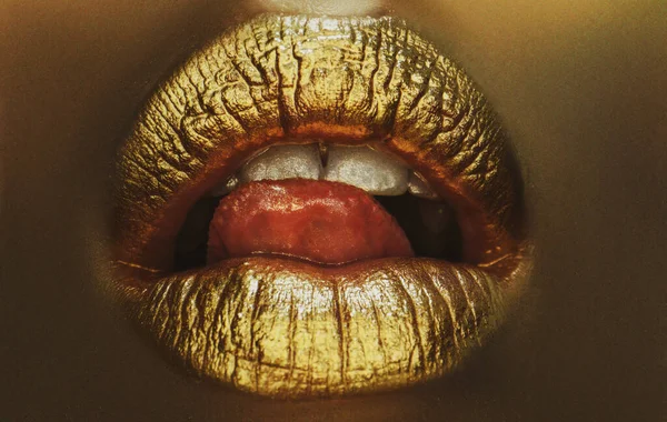 Sexy tong. Sensuele lik. Gouden lippen, gouden lipgloss op sexy lippen, metalen mond. Schoonheid vrouw make-up close up. — Stockfoto