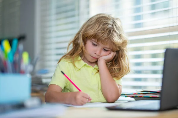 Tired schoolboy while doing homework. Child writing homework in school class. Funny child girl doing homework writing and reading at home. Little student at desk in school classroom. — 图库照片