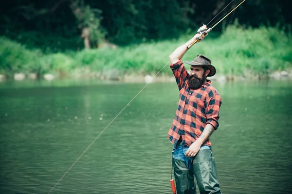 Pescador pescando en un río. Hombre pescador relajado con una caña de pescar en un día de verano. —  Fotos de Stock