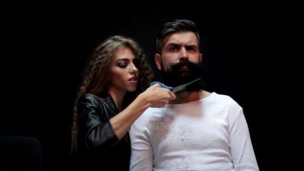 修剪长胡子。女理发师在沙龙里对一个残忍的男人刮胡子.理发师剪刀和直剃须刀，剃须。创意广告，女性剃须. — 图库视频影像