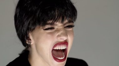 Çığlık atan surat yaklaş. Nefret ve öfke. Kızgın kadın çığlık atıyor. Duygusal bir yüz. Bağıran ağız, bağıran duygusal genç kadın. Kızgın ve üzgün öfkeli bağırış.