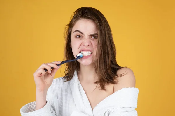 Mujer joven cepillándose los dientes. Feliz chica divertida cepillarse los dientes sobre un fondo aislado. Hermosa sonrisa amplia de mujer joven con grandes dientes blancos sanos. —  Fotos de Stock