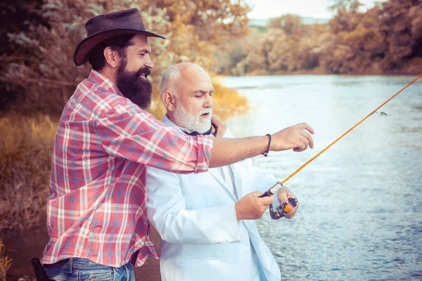 Volwassen oudere man met vriend vissen. Zomervakantie. Gelukkige vrolijke mensen. Baard mannen die vis vangen. Visser met vishengel. Activiteit en hobby. — Stockfoto