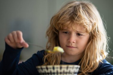 Evde kahvaltı yapan sevimli bir çocuk. Üzgün çocuk öğle yemeğinde sağlıklı tavuk çorbası içiyor. Mutsuz bebek evde yemek yiyor, kreşe gidiyor, anaokuluna gidiyor..