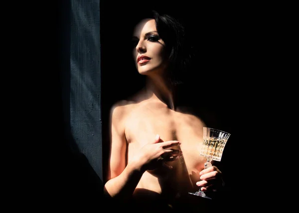 Приваблива і спокійна красива молода жінка з тонким сексуальним тілом зі скляним вином . — стокове фото