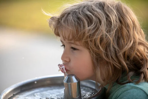 Dışarıdaki çeşmeden su içen çocuk portresini kapatın..