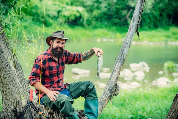 Fisherman fishing on a rever. Relaxed fisher man with a fishing rod on a summer day. — Stock Photo, Image