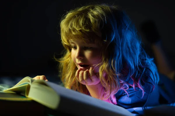 Barn läser böcker. Ungar lägger sig, pojkar läser en bok i sängen. Fantasi eller inlärningskoncept. — Stockfoto