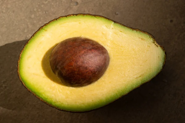 Avocado mit einer Hälfte, Makro Nahaufnahme. — Stockfoto