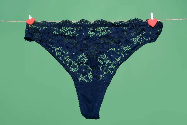Donne erotico biancheria intima nera mutandine appese sulla corda isolato su sfondo verde. Lace lingerie, biancheria intima donna. — Foto Stock