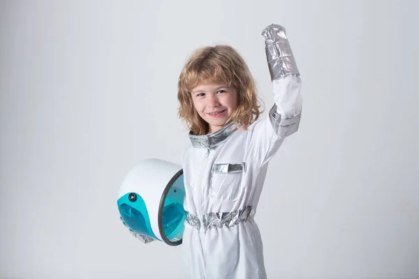 Bonito menino sorridente criança homem espacial em terno espacial segurando capacete isolado no fundo cinza. — Fotografia de Stock