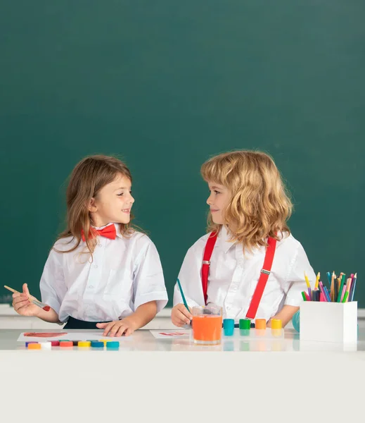 Educación infantil de artes y oficios. Niños de la escuela de retratos haciendo deberes de arte. Niños dibujando en la escuela primaria. — Foto de Stock