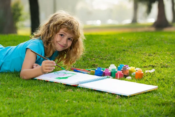Дети рисуют весной на природе. Ребенок наслаждается искусством и рисованием на заднем дворе или в весеннем парке. Дети рисуют карандашами на открытом воздухе. — стоковое фото