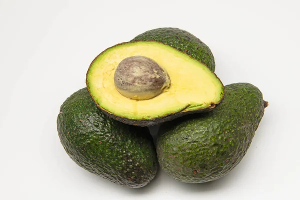 Aguacate aislado. Aguacate entero con medio aislado sobre fondo blanco con ruta de recorte. — Foto de Stock