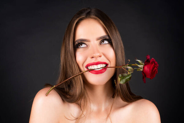 Rose flowers in a womans mouth. Red lips and rose. Beauty girl with sensual mouth. Sexy woman with red rose in teeth on black background. Woman day concept. Happy birthday day.