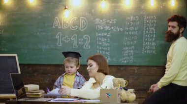 Çocukların öğrenme ve eğitim konsepti. Mutlu bir aile. Anne baba ve oğul birlikte okuyorlar. İlkokuldan bir çocuk. İlkokuldaki öğrenci çocuklar..