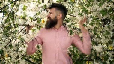 Açık havada bahar çiçekleriyle gülen komik hippi adam..