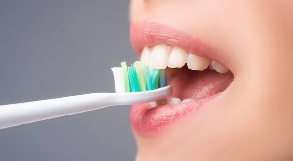 Mulut wanita menggosok gigi. Senyum indah wanita muda dengan gigi putih yang sehat. Latar belakang terisolasi. Perawatan gigi. — Stok Foto