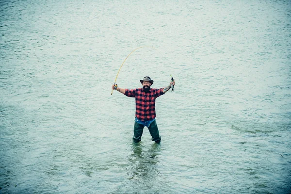 Uomo pescatore in acqua cattura dei pesci, vista dall'alto. Uomo con canna da pesca, pescatori uomini in acqua di fiume all'aperto. Pesca estiva hobby. — Foto Stock