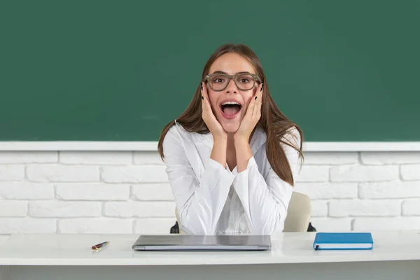 Estudiante sorprendida, linda joven en clase en la escuela. La secundaria sorprendió al estudiante en el aula. Sorprendida chica de la escuela. — Foto de Stock