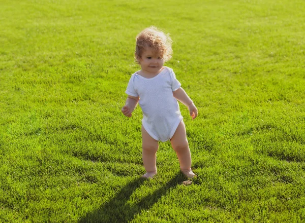 Baby jongen peuter wandelen in een park op heldere lentedag. Ontwikkeling van het kind. — Stockfoto
