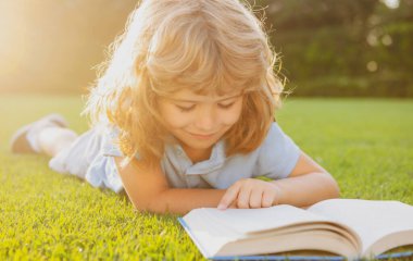 Çim arka planıyla ilgili güzel bir çocuk kitabı. Çocuklar parkta kitap okuyor..