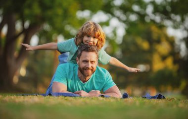 Baba oğul yazın gülümsüyor bahar parkında arka plan bulanıklaşıyor..