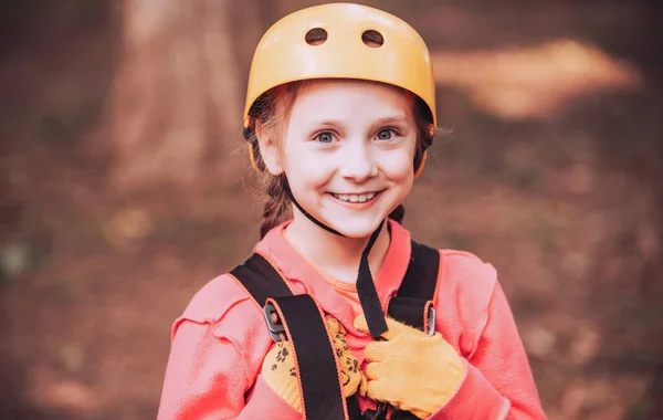 Last nät klättring och hängande timmer. Söta barn i klättring säkerhetsutrustning i en trädkoja eller i en reppark klättrar repet. Happy Child på sommaren. — Stockfoto