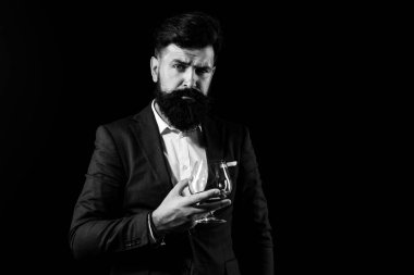 Sommelier pahalı alkol içecek tadı. Yakışıklı sakallı işadamı pahalı konyak içiyor. Viski barda Çekici Barmen.